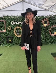 Customer wearing a black jacket and pant Elliatt set for a race day.